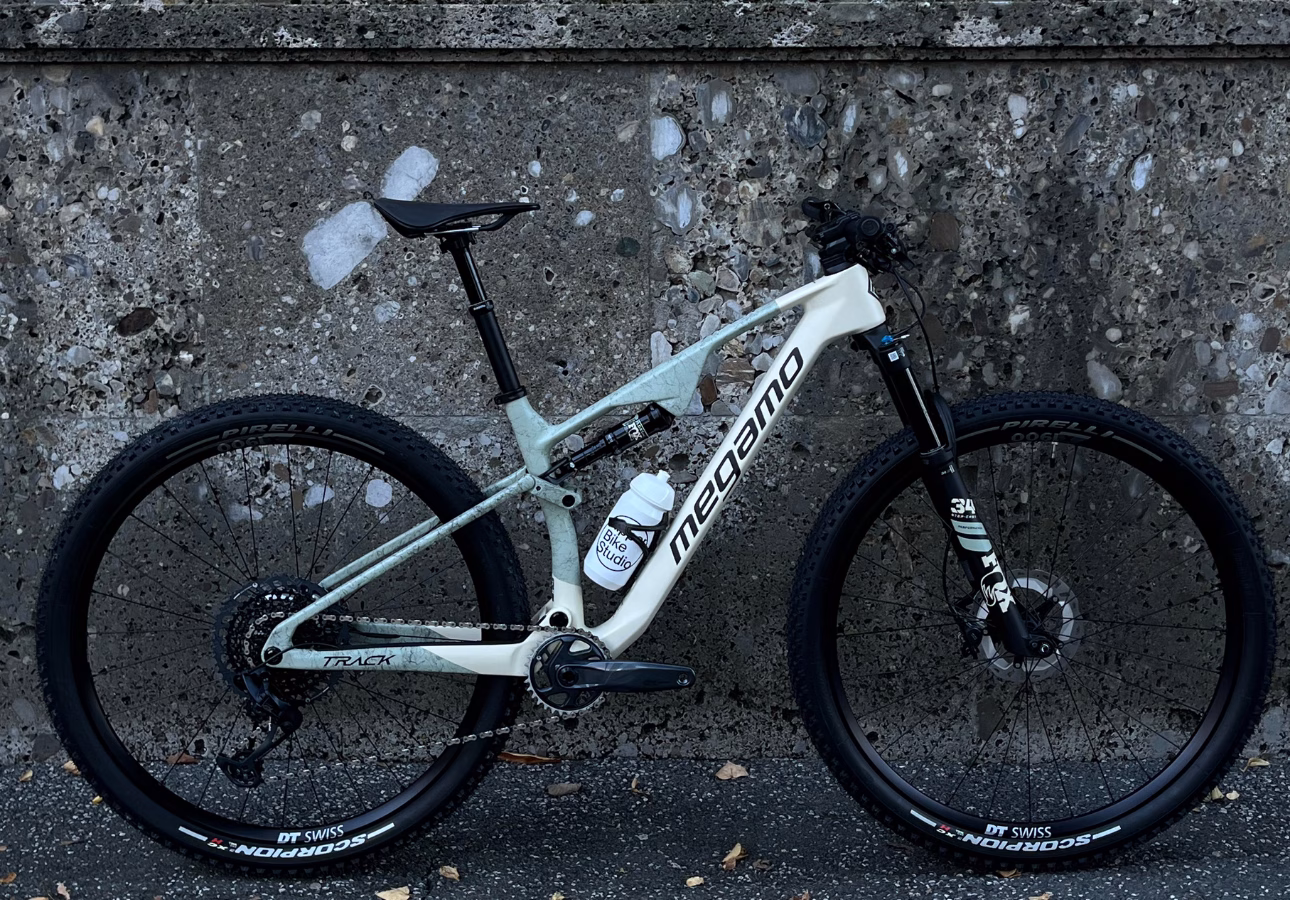 Megamo Bike lehnt schlicht an einer neutralen Wand.