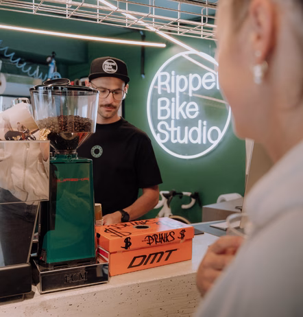 Neonlogo von Ripper Bike Studio an der Werkstattwand, aufgenommen im Innenraum.